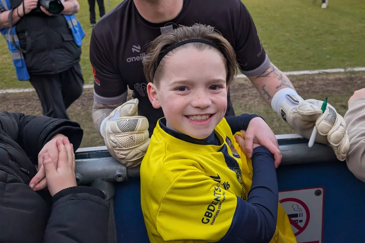 A young player meeting the Farnborough FC goalkeeper at the hoardings after the final whistle