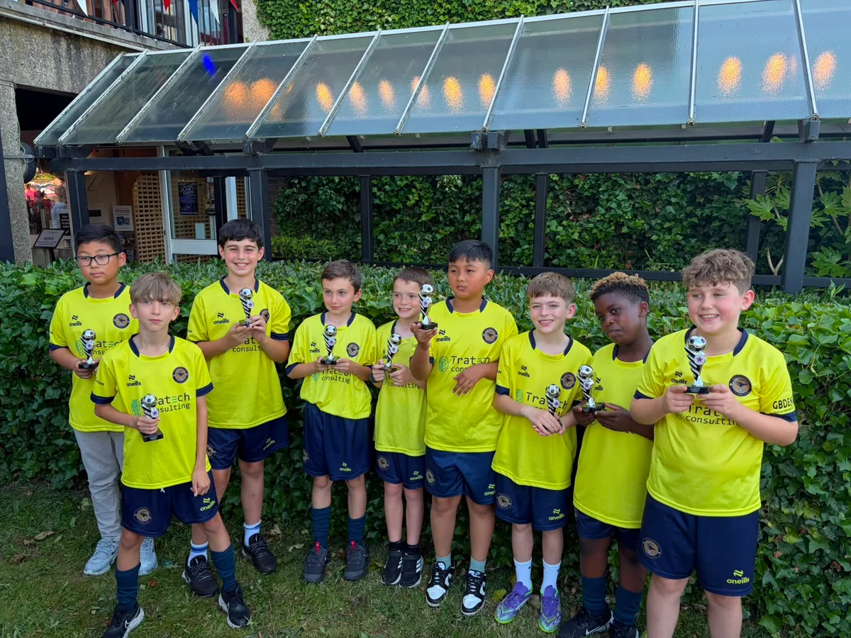 Nine players lined up outside with their trophies after the presentation