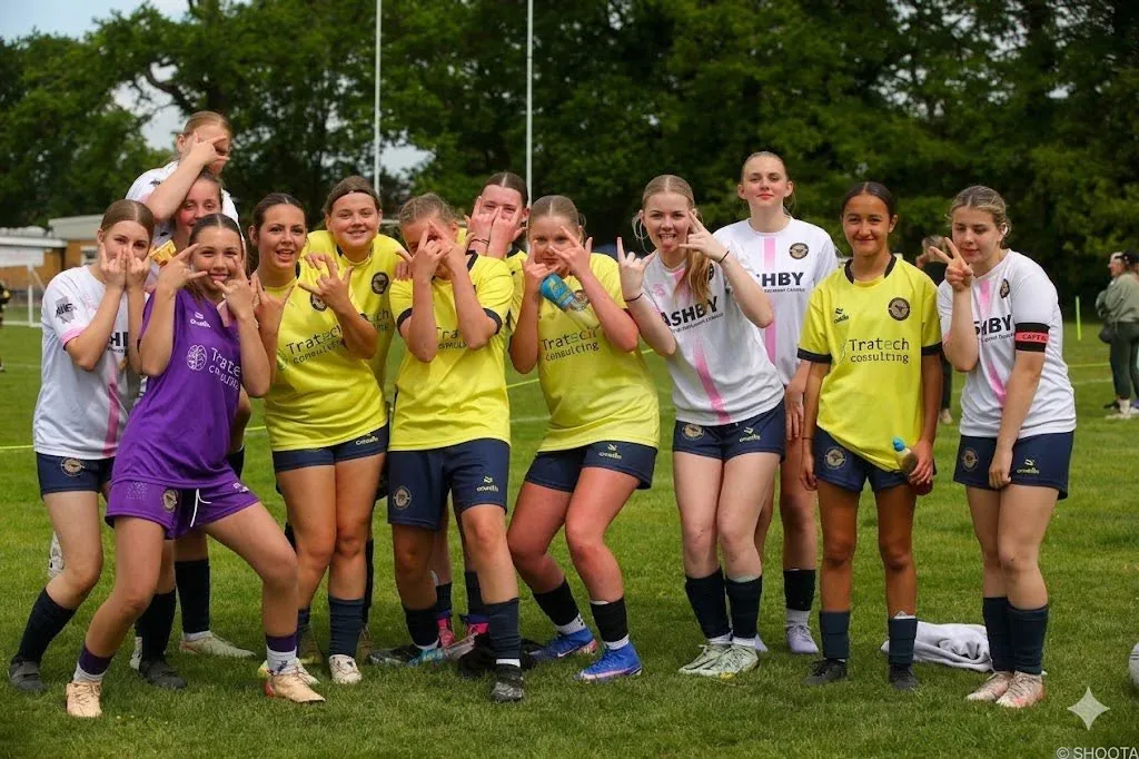 Our girls' squad laughing together on the pitch.