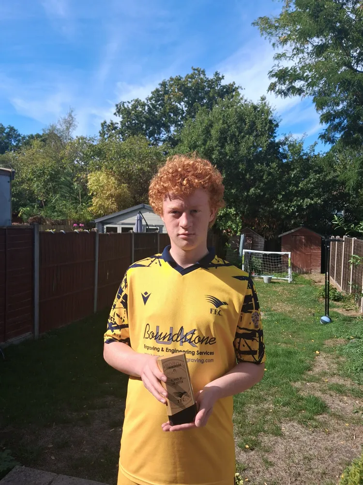 Trophy held in both hands in a back garden
