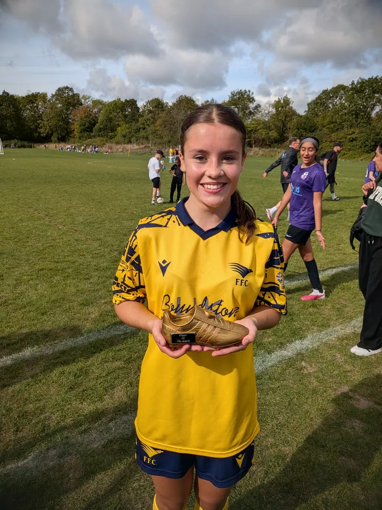 A wide smile and a golden boot trophy resting flat in both hands