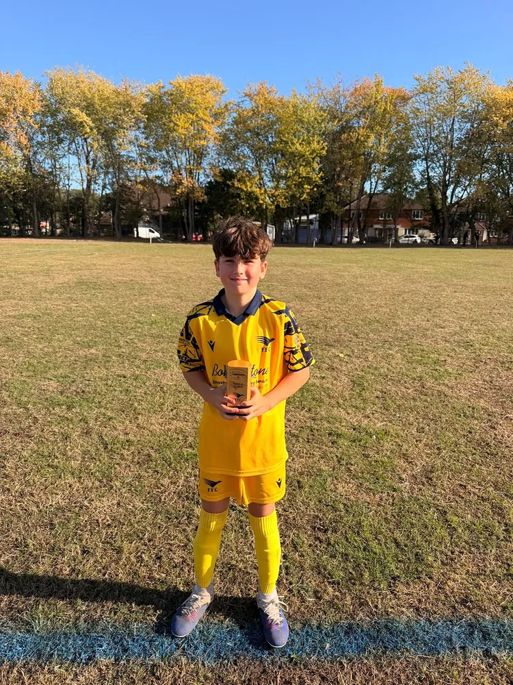 A quiet, proud smile on the touchline, the club trophy cradled in both hands