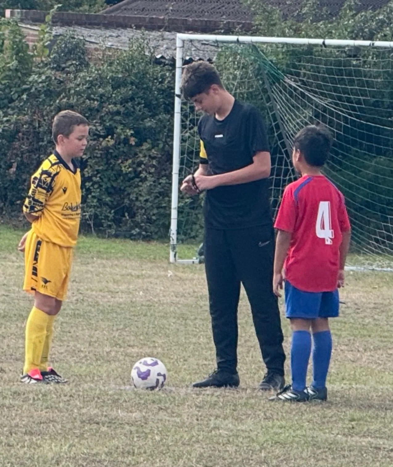 A young Farnborough Juniors referee starting a match, with a player from each side